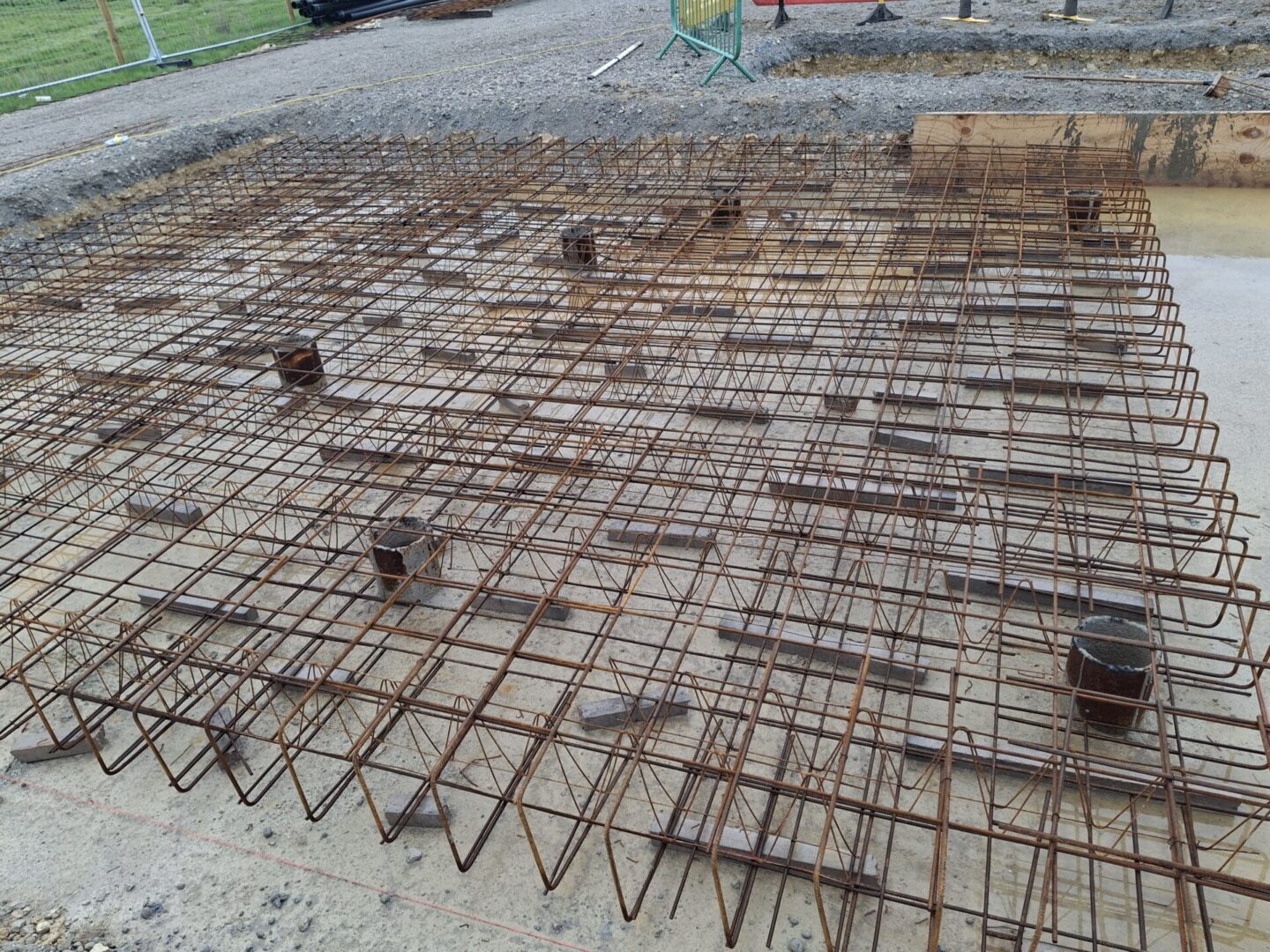 Reinforced steel mesh on concrete construction site.